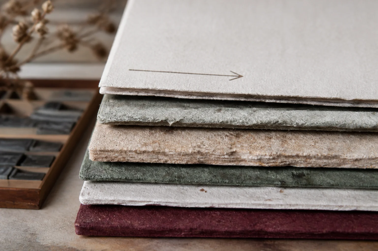 Stacked cotton, textured, and recycled paper samples showing different thicknesses and grain directions